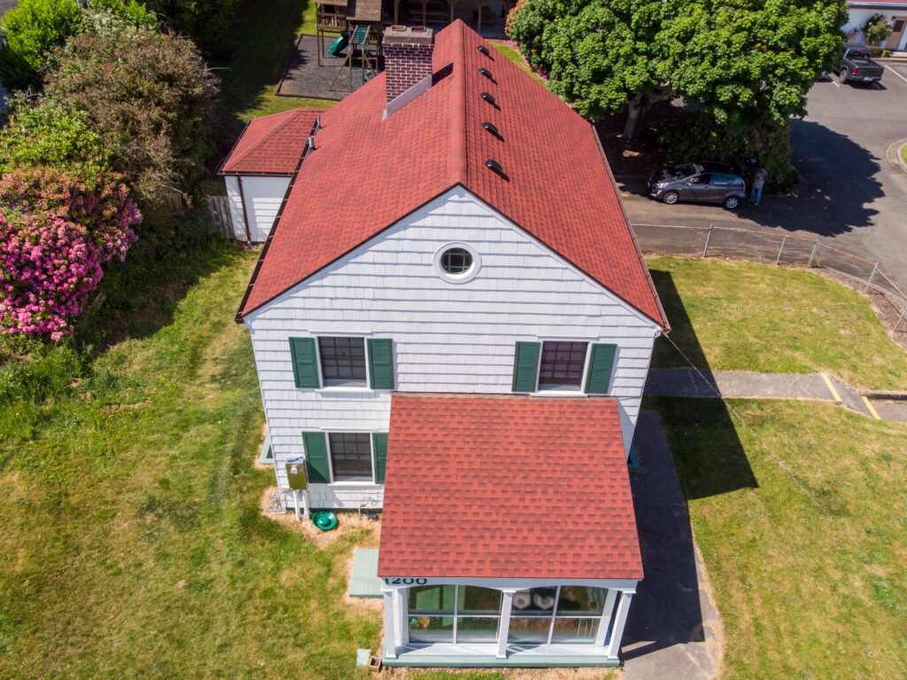 An overhead shot of a white house with a red roof.