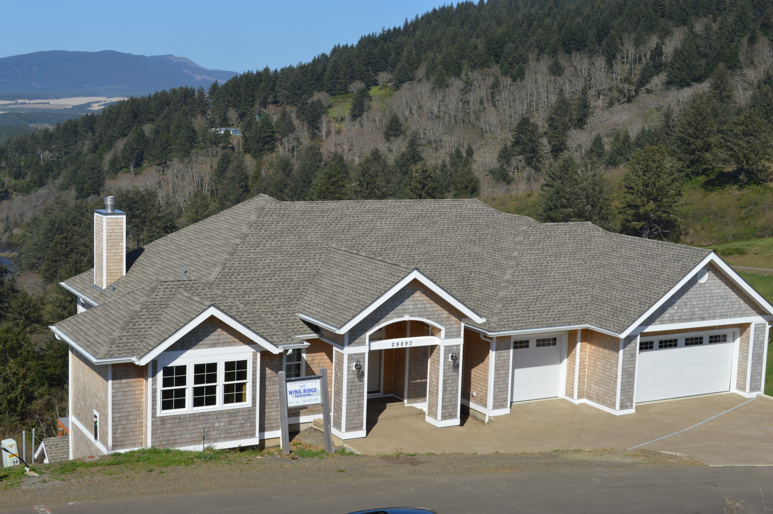 An overhead shot of a large, new roof with mountains and the ocean in the background.
